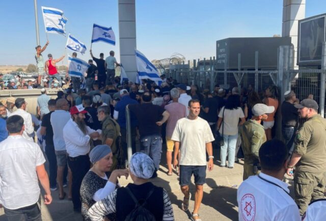 Manifestantes de direita agitam bandeiras israelenses do lado de fora do centro de detenção de Sde Teiman