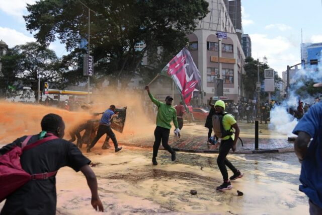 Os manifestantes dispersam-se enquanto a polícia do Quénia pulveriza um canhão de água contra eles durante um protesto contra a proposta de aumento de impostos num projecto de lei financeira no centro de Nairobi, Quénia, na terça-feira, Junho.  25 de outubro de 2024. (AP Photo/Brian Inganga)