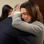 Alec Baldwin e sua esposa Hilaria Baldwin se abraçam durante seu julgamento por homicídio culposo
