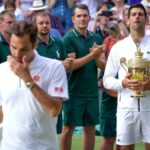 Novak Djokovic, da Sérvia, segura o troféu de Wimbledon enquanto observa Roger Federer, da Suíça, ir embora em 2019