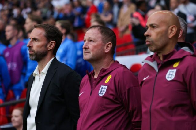 Gareth Southgate com sua comissão técnica no campo de futebol