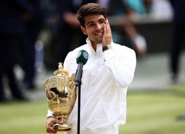 Carlos Alcaraz, da Espanha, segura o troféu do vencedor ao discursar após a vitória sobre Novak Djokovic, da Sérvia.