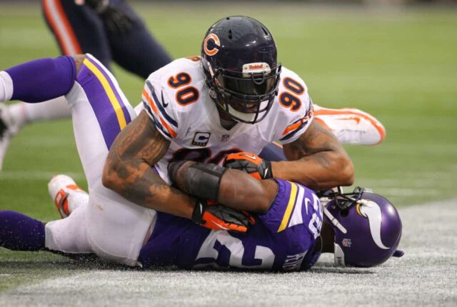 MINNEAPOLIS, MN - 1 DE DEZEMBRO: Adrian Peterson # 28 do Minnesota Vikings é abordado por Julius Peppers # 90 do Chicago Bears em 1 de dezembro de 2013 no Mall of America Field no Hubert Humphrey Metrodome em Minneapolis, Minnesota. 