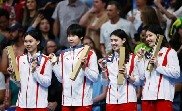 Medalhista de bronze da China comemora no pódio após a corrida.