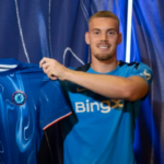 Filip Jorgensen segura uma camisa do Chelsea após o anúncio de sua transferência para o clube