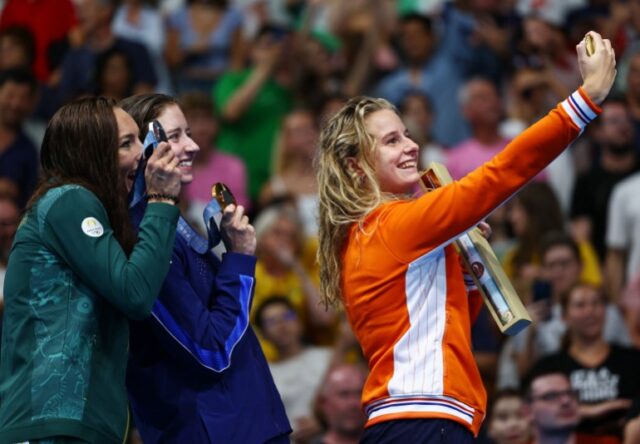 Olimpíadas de Paris 2024 - Natação - Cerimônia de vitória nos 200m peito feminino - Paris La Defense Arena, Nanterre, França - 01 de agosto de 2024. A medalhista de ouro Kate Douglass, dos Estados Unidos, posa para uma selfie no pódio após vencer com a medalhista de prata Tatjana Smith, da África do Sul e o medalhista de bronze Tes Schouten, da Holanda.  REUTERS/Ueslei Marcelino