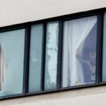 Pessoas olham pela janela de um hotel em Rotherham