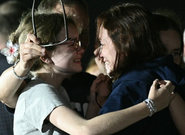 A jornalista Alsu Kurmasheva abraça as filhas no aeroporto.  Eles parecem muito felizes