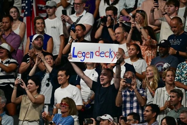 Uma apoiadora da medalhista de ouro norte-americana Katie Ledecky segura uma placa durante a cerimônia do pódio da prova feminina de natação de estilo livre de 800m durante os Jogos Olímpicos de Paris 2024, na Arena Paris La Defense, em Nanterre, a oeste de Paris, em 3 de agosto de 2024. (Foto por Manan VATSYAYANA/AFP)