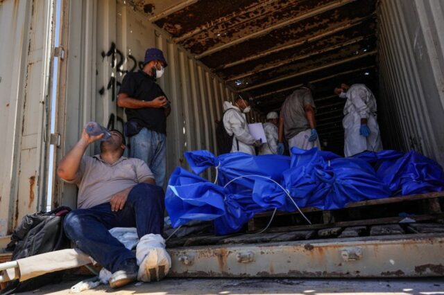 Homens se preparam para remover corpos de um contêiner depois de terem sido levados e posteriormente libertados por Israel, antes de um funeral em massa em um cemitério em Khan Yunis, no sul da Faixa de Gaza, em 5 de agosto de 2024, em meio ao conflito em curso entre Israel e o Hamas palestino grupo militante.  (Foto de Bashar TALEB/AFP)