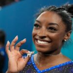 Simone Biles, dos Estados Unidos, comemora com seu colar GOAT após conquistar a medalha de ouro durante as finais gerais da ginástica artística feminina na Bercy Arena nos Jogos Olímpicos de Verão de 2024, quinta-feira, 1º de agosto de 2024, em Paris, França. (Foto AP/Charlie Riedel)