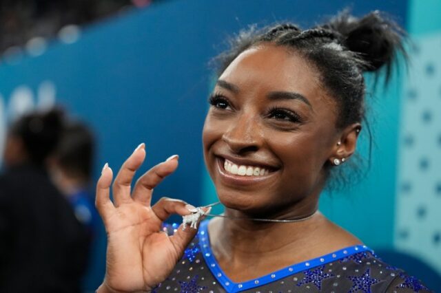 Simone Biles, dos Estados Unidos, comemora com seu colar GOAT após conquistar a medalha de ouro durante as finais gerais da ginástica artística feminina na Bercy Arena nos Jogos Olímpicos de Verão de 2024, quinta-feira, 1º de agosto de 2024, em Paris, França. (Foto AP/Charlie Riedel)