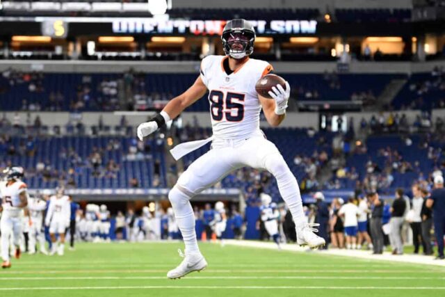 INDIANÁPOLIS, INDIAN - 11 DE AGOSTO: Lucas Krull # 85 do Denver Broncos recebe um passe e salta no ar durante o aquecimento antes de um jogo de pré-temporada contra o Indianapolis Colts no Lucas Oil Stadium em 11 de agosto de 2024 em Indianápolis, Indiana. 