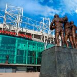 Manchester, Reino Unido – 19 de maio de 2018: A escultura de bronze United Trinity composta por George Best, Denis Law e Sir Bobby Charlton em frente ao estádio Old Trafford