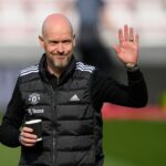 O técnico do Manchester United, Erik ten Hag, acena para a câmera com um café na mão