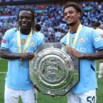 Jeremy Doku e Oscar Bobb, do Manchester City, comemoram com o troféu após a vitória de seu time na disputa de pênaltis durante o FA Community Shield de 2024