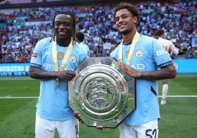     Jeremy Doku e Oscar Bobb, do Manchester City, comemoram com o troféu após a vitória de seu time na disputa de pênaltis durante o FA Community Shield de 2024