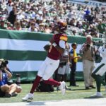 EAST RUTHERFORD, NOVA JERSEY - 10 DE AGOSTO: Jayden Daniels nº 5 do Washington Commanders corre para um touchdown contra o New York Jets na primeira metade do jogo de pré-temporada contra o MetLife Stadium em 10 de agosto de 2024 em East Rutherford, Nova Jersey