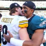 FILADÉLFIA, PENSILVÂNIA - 30 DE OUTUBRO: Kenny Pickett nº 8 do Pittsburgh Steelers e Jalen Hurts nº 1 do Philadelphia Eagles se encontram no meio-campo após o jogo no Lincoln Financial Field em 30 de outubro de 2022 na Filadélfia, Pensilvânia.