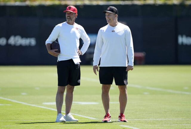 SANTA CLARA, CALIFÓRNIA - 04 DE JUNHO: O técnico Kyle Shanahan (L) e o gerente geral John Lynch (R) do San Francisco 49ers observam durante um mini acampamento em 04 de junho de 2024 em Santa Clara, Califórnia.