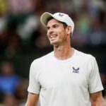 Andy Murray retratado em ação com um enorme sorriso