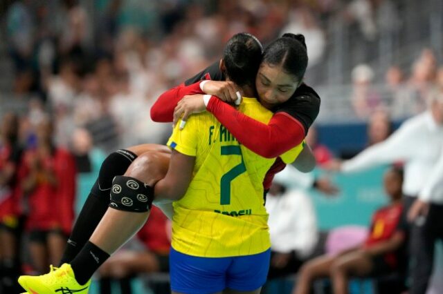 Frossard Tamires Araujo, do Brasil, carrega Albertina Kassoma, de Angola, para fora do campo depois que ela se machucou durante a partida de handebol feminino nos Jogos Olímpicos de Verão de 2024