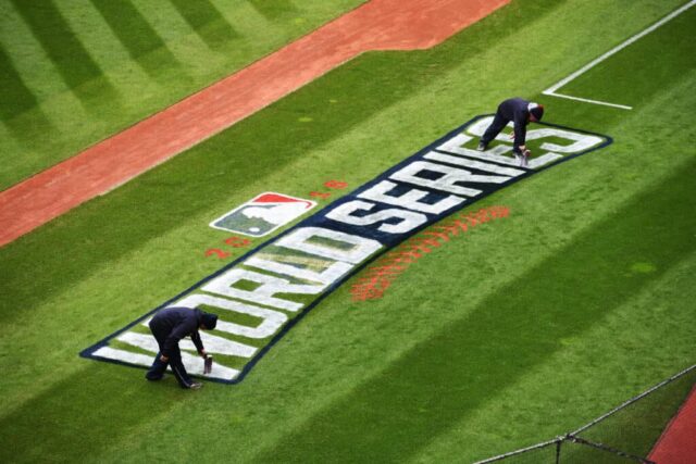 Membros da equipe de campo do Cleveland Indians pintam o logotipo da MLB World Series no campo antes do Media Day no Progressive Field em 24 de outubro de 2016 em Cleveland, Ohio.