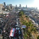 Manifestantes marcham fora do porto de Beirute em 4 de agosto de 2023, para marcar o terceiro aniversário da explosão mortal no porto que devastou grandes áreas da capital libanesa em 2020 (Arquivo: Kameel RAYES / AFP)