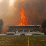 Chamas de um incêndio devastador atingem um estádio de futebol