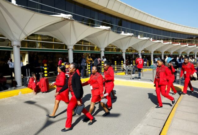 Trabalhadores da Kenya Airways passam por passageiros que aguardam seus voos durante uma greve dos trabalhadores sindicais dos aeroportos do Quênia para protestar contra um acordo proposto para o Grupo Adani da Índia ADEL.NS, para alugar o Aeroporto Internacional Jomo Kenyatta (JKIA) por 30 anos, em Nairobi, Quênia, setembro 11, 2024. REUTERS/Thomas Mukoya