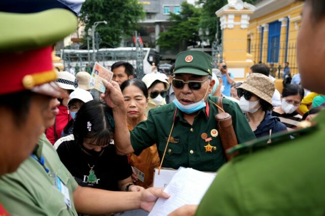 Um veterano da guerra do Vietnã e vítima de fraude (C) chega com outras vítimas para comparecer ao processo judicial do magnata imobiliário vietnamita Truong My Lan 