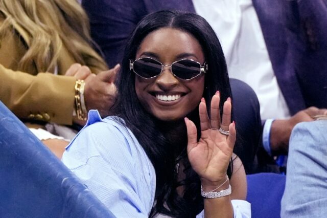 A medalhista de ouro olímpica Simone Biles acena durante o intervalo da partida entre Jessica Pegula, dos Estados Unidos, e Iga Świątek, da Polônia, durante as quartas de final do campeonato de tênis do Aberto dos Estados Unidos, quarta-feira, 4 de setembro de 2024, em Nova York. (AP Photo/Eduardo Muñoz Alvarez)