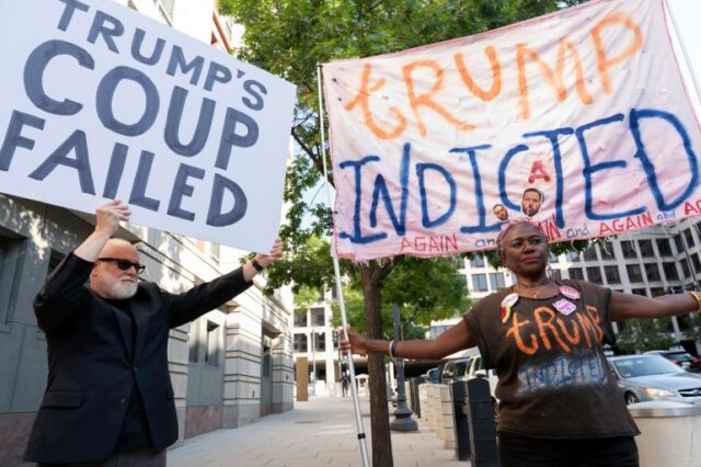 Manifestantes em Washington, DC, erguem cartazes que dizem 