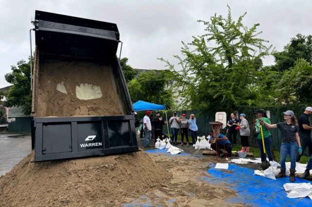 Moradores enchem sacos de areia para proteger suas casas em antecipação à tempestade tropical Francine