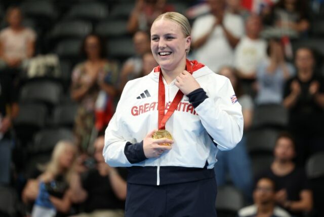 Faye Rogers fotografada com um enorme sorriso e uma medalha de ouro paraolímpica no pescoço