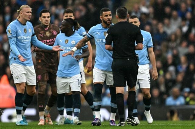 Jogadores do Manchester City cercam Michael Oliver