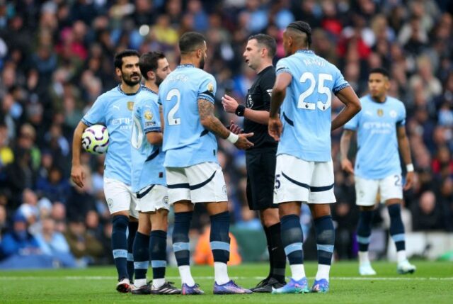 Bernardo Silva e Kyle Walker do Manchester City conversam com o árbitro Michael Oliver durante a partida da Premier League entre Manchester City e Arsenal