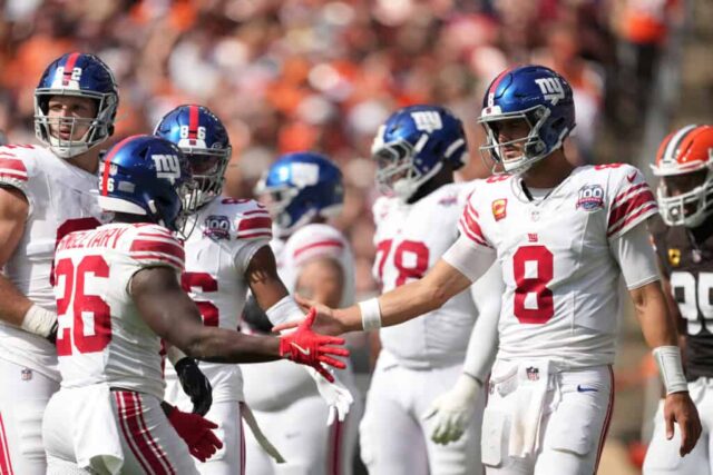 CLEVELAND, OHIO - 22 DE SETEMBRO: Devin Singletary #26 e quarterback Daniel Jones #8 do New York Giants high five durante o terceiro quarto contra o Cleveland Browns no Cleveland Browns Stadium em 22 de setembro de 2024 em Cleveland, Ohio