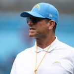 CHARLOTTE, CAROLINA DO NORTE - 15 DE SETEMBRO: O técnico Jim Harbaugh do Los Angeles Chargers observa antes de um jogo contra o Carolina Panthers no Bank of America Stadium em 15 de setembro de 2024 em Charlotte, Carolina do Norte.