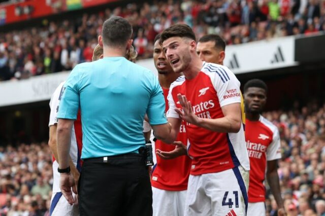 Declan Rice, do Arsenal, interage com o árbitro Chris Kavanagh após receber o segundo cartão amarelo durante a partida da Premier League entre Arsenal FC e Brighton & Hove Albion FC no Emirates Stadium