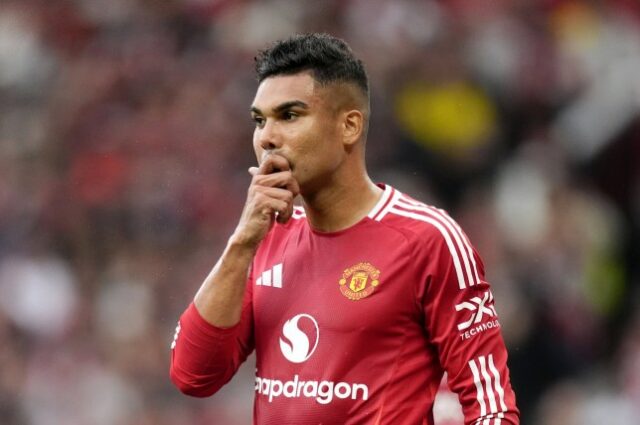 Casemiro, meio-campista do Manchester United, observa pensativamente a derrota de seu time contra o Liverpool