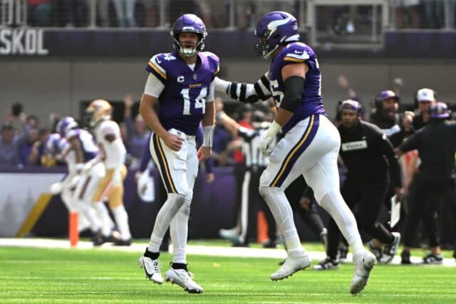 MINNEAPOLIS, MINNESOTA - 15 DE SETEMBRO: Sam Darnold #14 do Minnesota Vikings comemora com Brian O'Neill #75 após um touchdown contra o San Francisco 49ers durante o segundo quarto no US Bank Stadium em 15 de setembro de 2024 em Minneapolis, Minnesota. 