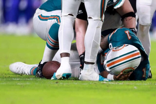 MIAMI GARDENS, FLÓRIDA - 12 DE SETEMBRO: Tua Tagovailoa nº 1 do Miami Dolphins cai no chão após colidir com Damar Hamlin nº 3 do Buffalo Bills durante o terceiro quarto do jogo no Hard Rock Stadium em 12 de setembro de 2024 em Miami Gardens , Flórida. 