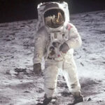 Imagem clássica de Buzz Aldrin em traje de astronauta na superfície da Lua.