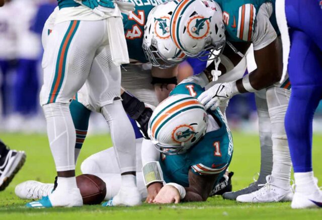 MIAMI GARDENS, FLÓRIDA - 12 DE SETEMBRO: Tua Tagovailoa nº 1 do Miami Dolphins cai no chão após colidir com Damar Hamlin nº 3 do Buffalo Bills durante o terceiro quarto do jogo no Hard Rock Stadium em 12 de setembro de 2024 em Miami Gardens , Flórida.