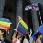 Participantes seguram bandeiras durante uma manifestação em apoio aos feridos durante os protestos de 5 de julho, quando uma marcha do orgulho foi interrompida por membros de grupos violentos