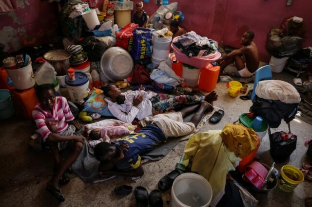 Pessoas deslocadas pela violência da guerra de gangues vivem dentro de uma sala de aula na escola Darius Denis, que foi transformada em um abrigo onde pessoas vivem em condições precárias, em Porto Príncipe, Haiti, em 5 de maio de 2024. Quase metade da população do país está lutando para se alimentar devido ao conflito, sem poder trabalhar, as famílias dependem de rações alimentares e kits de higiene trazidos por organizações não-governamentais