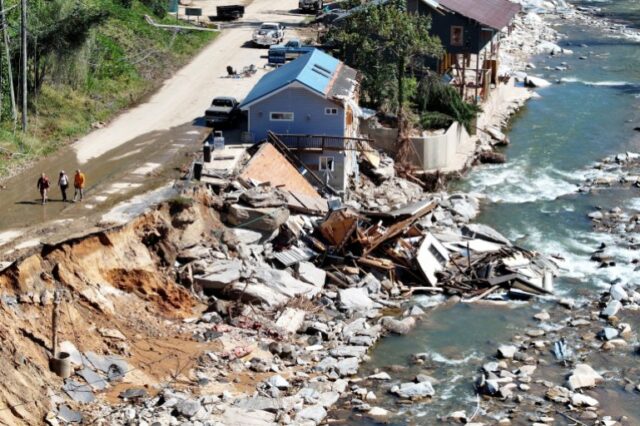 BAT CAVE, NORTH CAROLINA - OUTUBRO 08: Uma vista aérea de pessoas passando por edifícios destruídos e danificados após a inundação do furacão Helene em 8 de outubro de 2024 em Bat Cave, Carolina do Norte. A Caverna Bate foi particularmente atingida pelas enchentes. Os esforços de recuperação continuam, pois o número de mortos aumentou para mais de 230, enquanto o poderoso furacão Milton está a caminho de atingir a Flórida. Mario Tama/Getty Images/AFP (Foto de MARIO TAMA / GETTY IMAGES NORTH AMERICA / Getty Images via AFP)