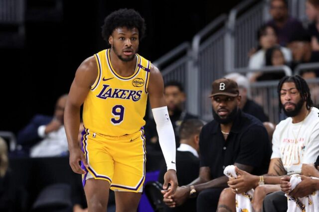 PALM SPRINGS, CALIFÓRNIA - 04 DE OUTUBRO: LeBron James #23 assiste ao jogo do banco enquanto Bronny James #9 do Los Angeles Lakers observa durante o segundo tempo de um jogo contra o Minnesota Timberwolves na Acrisure Arena em 04 de outubro de 2024 em Palm Springs, Califórnia. 