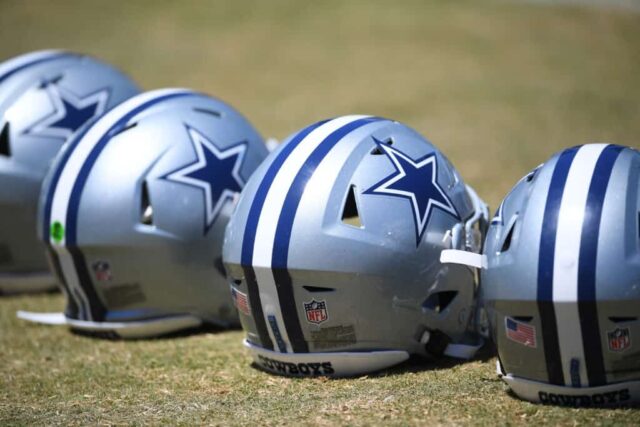 Uma visão detalhada dos capacetes do Dallas Cowboys alinhados em campo durante o campo de treinamento no River Ridge Complex em 3 de agosto de 2021 em Oxnard, Califórnia.